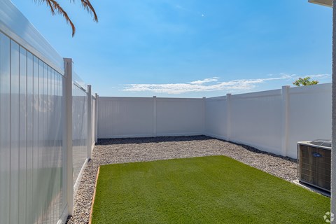 a backyard with a grass lawn and a fence